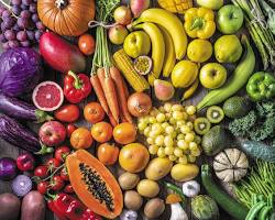 Image of a person eating a plate of colorful fruits and vegetables
